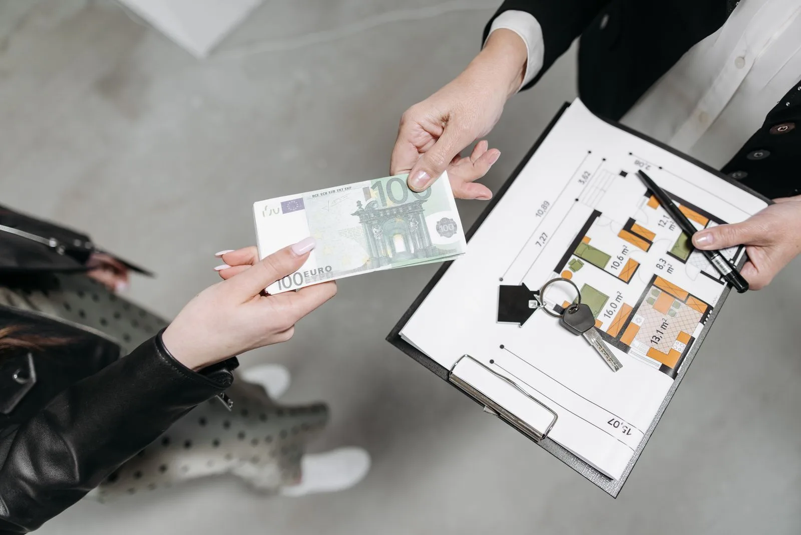 Euro banknotes, house keys and a floor plan representing the costs of buying property in Portugal